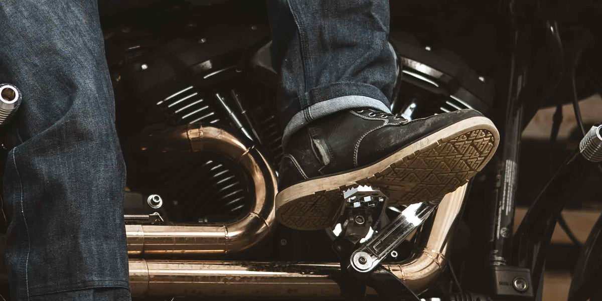 Black leather moc toe motorcycle boot worn while riding